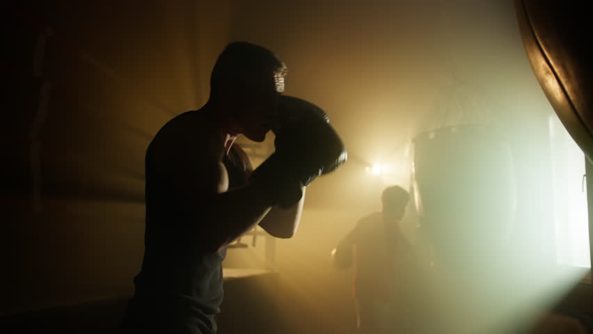 Portrait of professional sportsman mixing intense cardio and strength training. Close-up shot of a young guy kicking a punching bag during boxing workout. High quality 4k footage Royalty-Free Stock Footage #1100962183