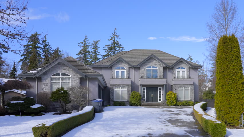 Establishing shot of two story stucco luxury house with big tree and nice landscape at winter in Vancouver, Canada, North America. Day time on December 2021. ProRes 422 HQ.