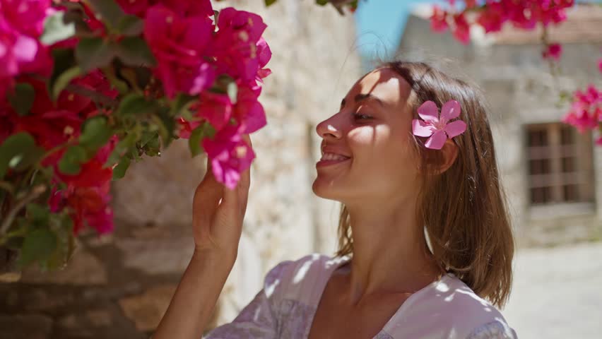 slow motion Close up portrait of smiling young attractive woman holding tenderness pink flower near face and looking to camera Royalty-Free Stock Footage #1100965273