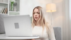 Sad young blond woman talk with psychotherapist at online distance remote counselling session indoors Depressed girl discussing problem with psychological support by laptop computer at home