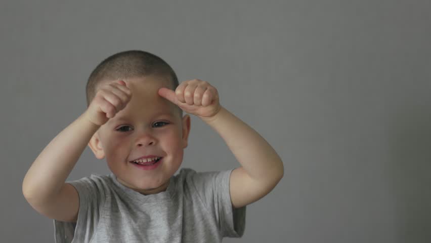 Happy laughing child boy showing two fists thumb up on camera. male kid preschooler making face show satisfied sign success gesture concept happy life double thumb up. boy 4 years old grey t-shirt | Shutterstock HD Video #1100967089