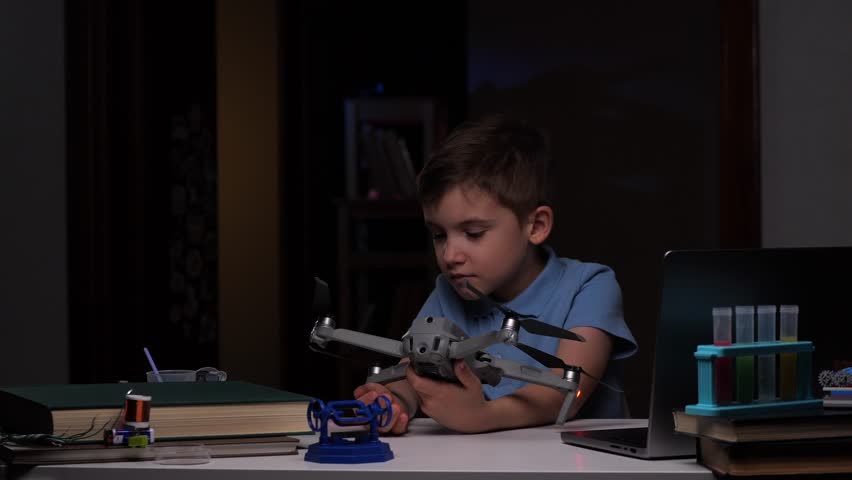 little boy studying drone copter device