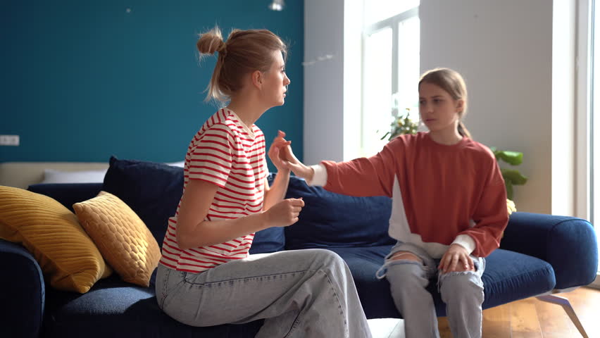 Stubborn teen girl daughter rejecting mother, upset worried woman mother dealing with difficult teenage child, mom and adolescent kid having conflict sitting together on sofa in living room at home Royalty-Free Stock Footage #1100970393