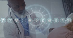 Animation of icons and data over african american male doctor with female patient. Global medicine, healthcare, digital interface, computing and data processing concept digitally generated video.