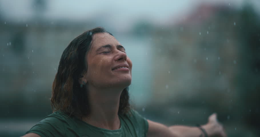 Free Woman Stand in the Rain, Looking up with Raised Arms. Female Enjoying Calm Rainy Day in the Nature Breathing Fresh Air, Smiling Attractive Lady Having Relax and Thanks the Universe for Life. 