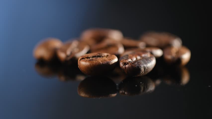 Close up of seeds of coffee. Fragrant coffee beans comes. reflection in glass rotation 4K