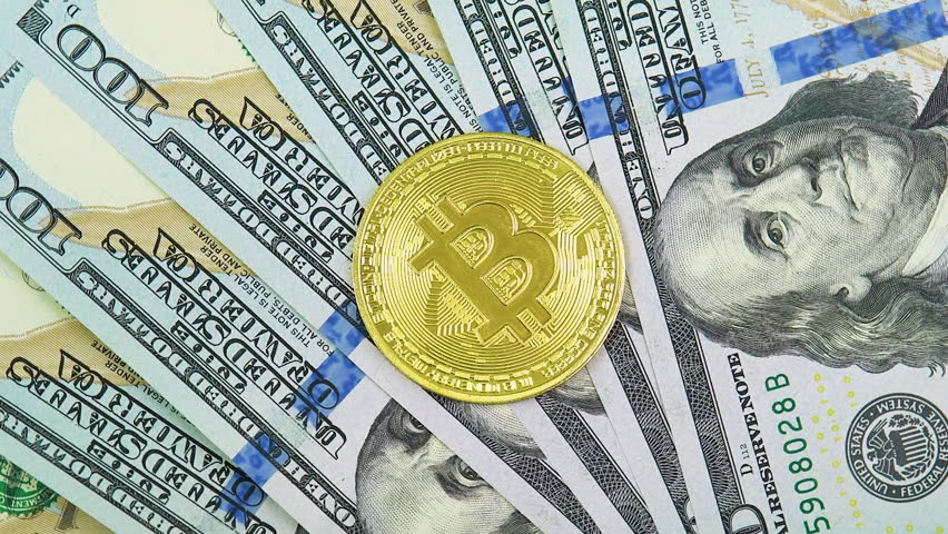 Golden symbolic coin Bitcoin on banknotes of one hundred dollars. Exchange bitcoin cash for a dollars. Cryptocurrency on US dollar bills. Digital modern method of payment. Savings, investments concept