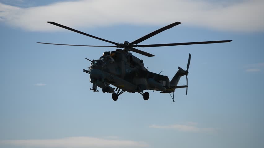 Ukrainian Mi-24 "Crocodile" attack helicopter landing. Heavy military war aircraft returning home. Amazing aircraft technology side view 4k UHD footage