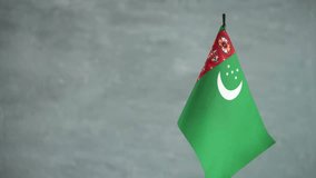 State flag of Turkmenistan waving on light background. Turkmenian flag and place for text