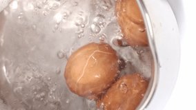 Chicken eggs are boiled in boiling water close up vertical video