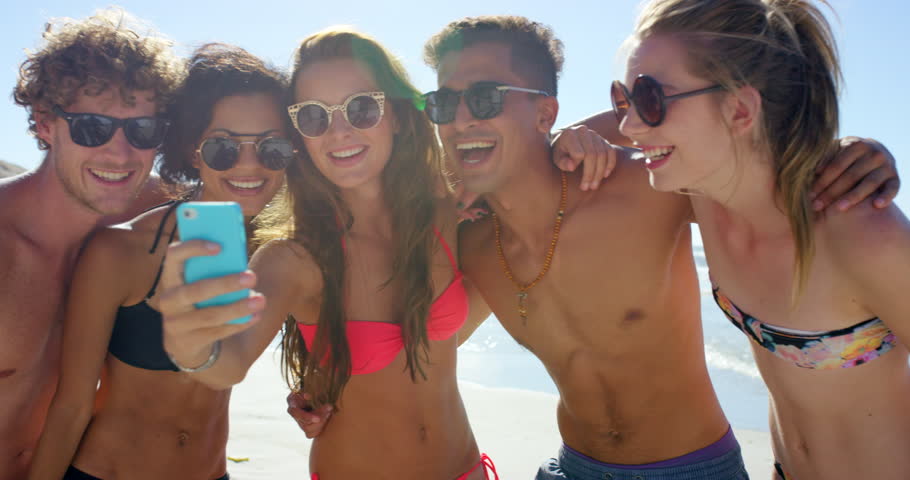 Phone, social media and friends take a selfie at a beach relaxing with freedom on a happy summer holiday in Bali. Smile, travel or crazy young people kiss on pictures on vacation in nature or ocean Royalty-Free Stock Footage #1100989951