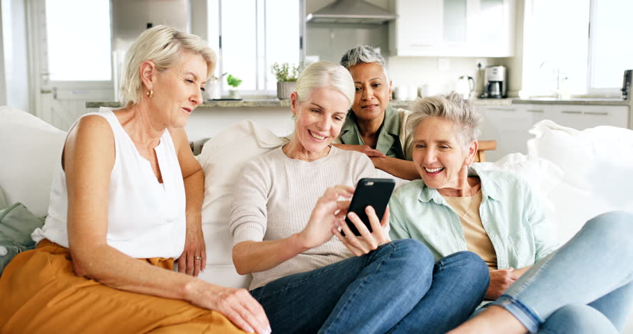Relax, friends and senior women on with phone on sofa looking at pictures, meme and social media on smartphone. Friendship, happiness and group of old females having fun, talking and chat together Royalty-Free Stock Footage #1100990807