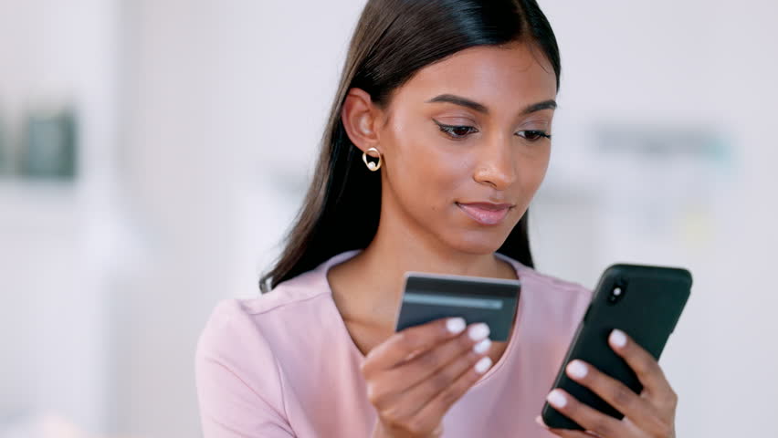 Woman on phone typing credit card details for online shopping, ebanking and ecommerce in home living room. Excited lady winning lottery, buying or ordering final stock item or investing and trading | Shutterstock HD Video #1100991811
