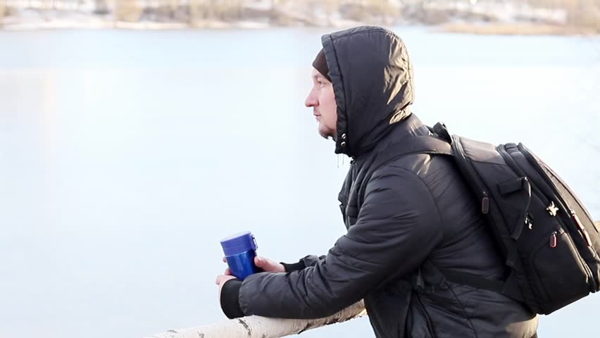 A young guy is resting outside the city in nature in winter