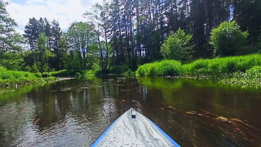 A blue inflatable kayak quickly floats down the river