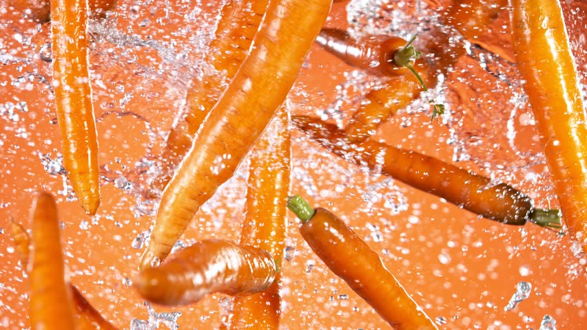 Super slow motion of fresh carrots with water splashes flying in the air. Filmed on high speed cinema camera, 1000 fps. Royalty-Free Stock Footage #1100994179