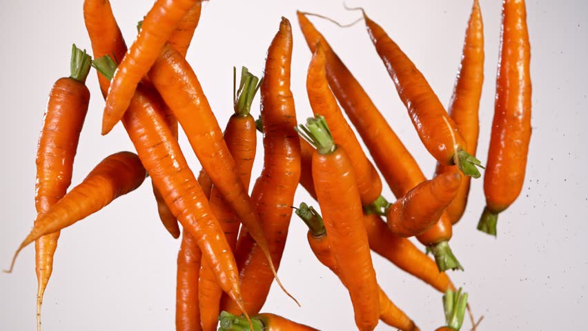 Super slow motion of fresh carrots with water splashes flying in the air. Filmed on high speed cinema camera, 1000 fps. Royalty-Free Stock Footage #1100994203