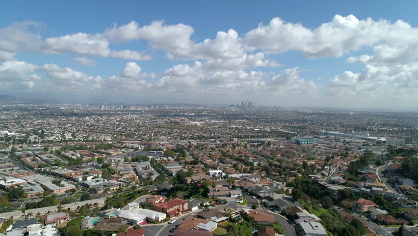 Aerial Backward Shot Of Residential Houses On Hills Under Cloudy Sky In City During Sunny Day - Los Angeles, California