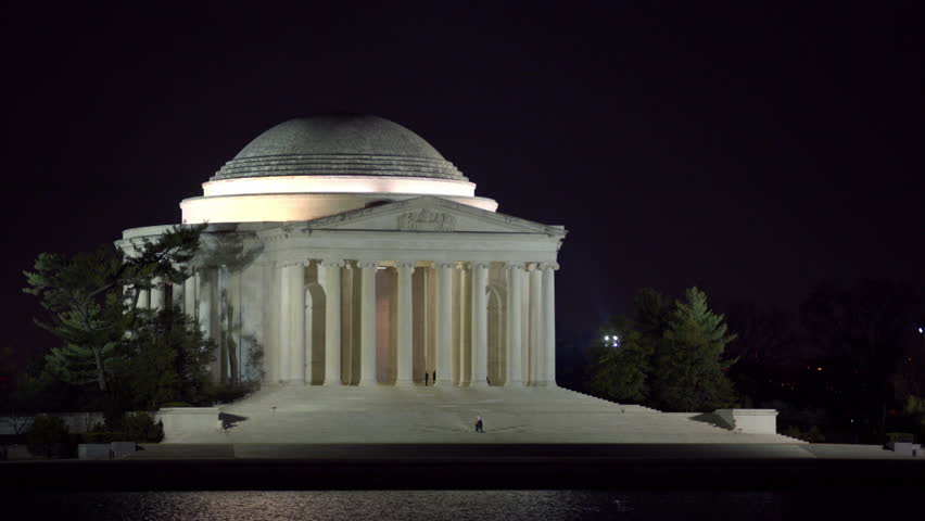 Lockdown Shot Of Tourists Exploring Thomas Jefferson Memorial Against Clear Sky In Front Of River At Night - Washington, District of Columbia