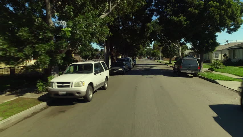 Aerial: Pov From A Car Driving Down A Quaint Residential Street With Tall Shady Trees - Los Angeles, California