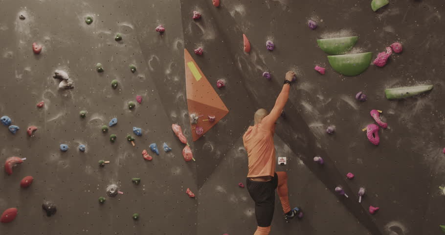Athlete Male Rock Climber Exercising on Indoor Climbing wall Royalty-Free Stock Footage #1100998361