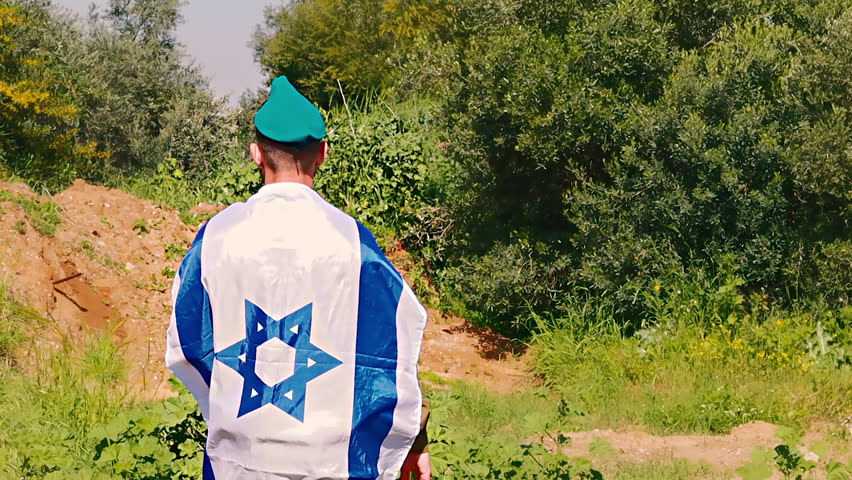 Israeli Army Soldier salutes with a large Flag of Israel on his back. Video themes: Army, IDF - Tzahal  or Israel Defense Forces, Independence Day Israel, Soldiers, Patriotism Royalty-Free Stock Footage #1101002933