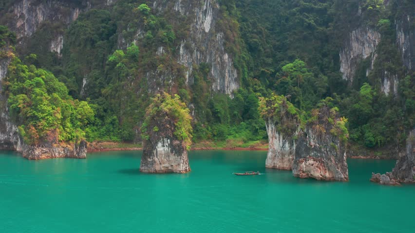 Three limestone rocks Three Brothers at Cheow Lan Lake, Khao Sok National Park, Surat Thani Province, South of Thailand. Aerial view 4K.