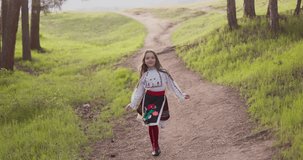 Bulgarian girl in traditional folklore costume running in forest of majestic mountain, 4k slow motion video. Bulgaria,Rhodope nature
