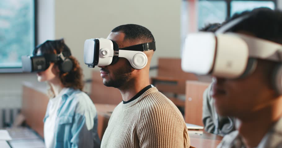Close up of multiethnic males and female students in VR glasses studying at college and turning heads left and right. Hi-tech study. Mixed-races young people learning technologic ways of education. | Shutterstock HD Video #1101012931