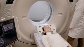 4k video CT x-ray examination of lung cancer in medical clinic. Patient girl lies on computed tomography bed and scanning lungs for diagnose lung cancer in medical clinic.