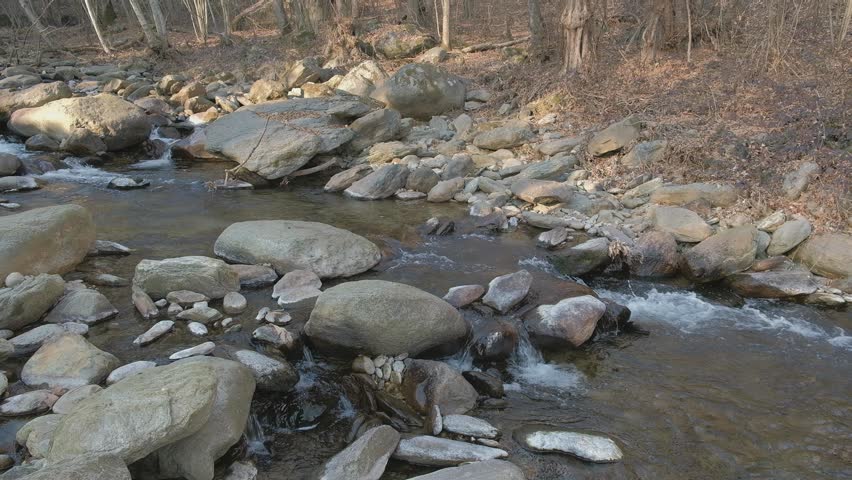 A rope bridge over a mountain stream. High quality 4k footage