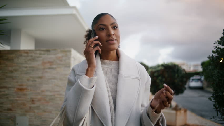 Attractive african american talking phone on street. Wealthy rich woman walking city hold key in hand. Stylish smiling businesswoman consult client partner after work. Successful real estate manager. Royalty-Free Stock Footage #1101016161