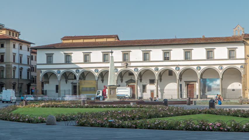 Public Square of Santa Maria Novella timelapse - one of the more important public squares in Florence. Flowerbeds and green grass. People sitting on a bench. Blue sky at summer day