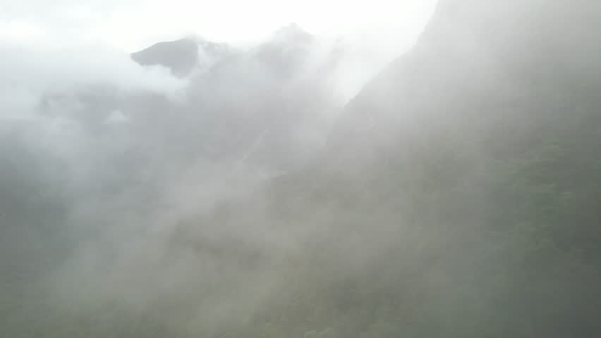 Drone fly in fog, Fiordland National Park, amazing high mountains landscape of New Zealand. Royalty-Free Stock Footage #1101017635