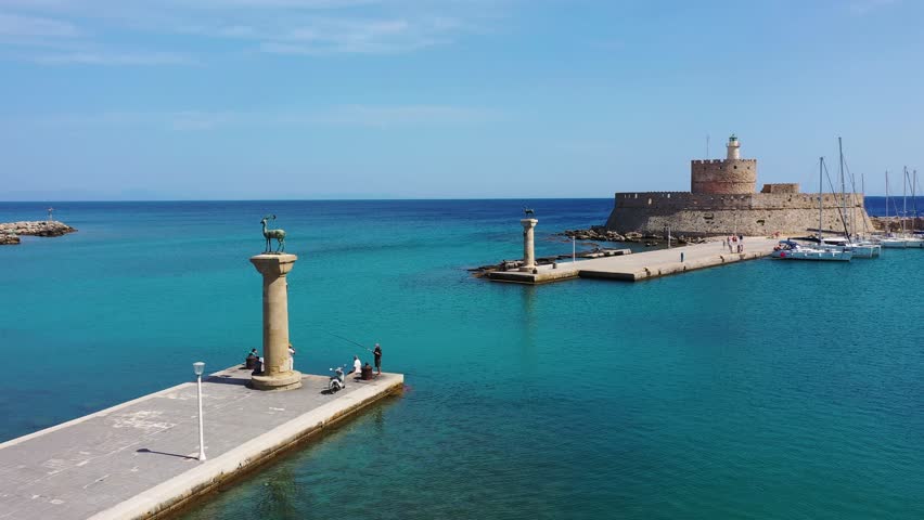 Mandraki port with deers statue, where The Colossus was standing and fort of St. Nicholas. Rhodes, Greece. Hirschkuh statue in the place of the Colossus of Rhodes, Rhodes, Greece Royalty-Free Stock Footage #1101018515