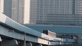 4K video with public transportation high speed train approaching on a bridge to station next to Toyosu Fish Market in Tokyo. Travel to Japan.