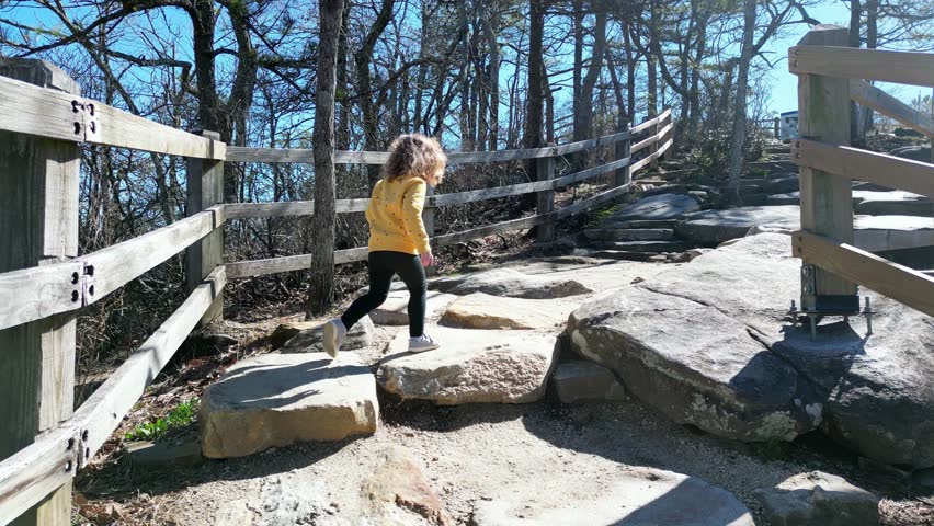 Toddler Hiking up mountain behind mother, pilot mountain, Mount Airy North Carolina