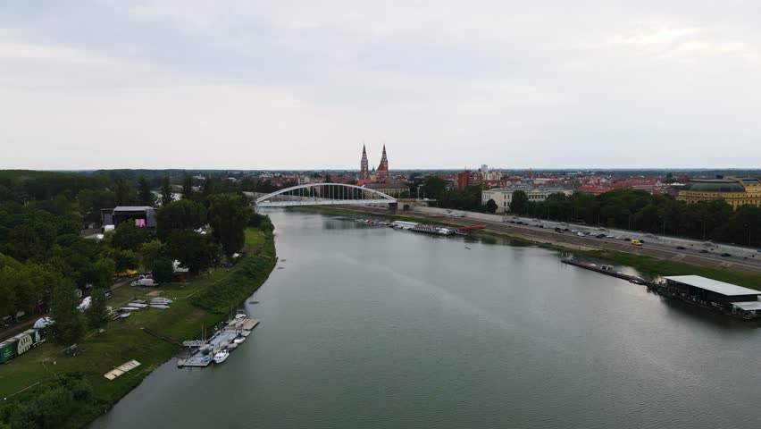 Flyover above Tisza River towards Belvárosi Bridge, Votive Church in Szeged, Hungary.