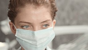 Closeup portrait of young beautiful blue eyed Caucasian female doctor in face mask looking at camera - Powered by Shutterstock - Get 15% off with code: PIKWIZARD15