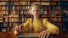 Schoolgirl in headphones having online lesson with private tutor via video call