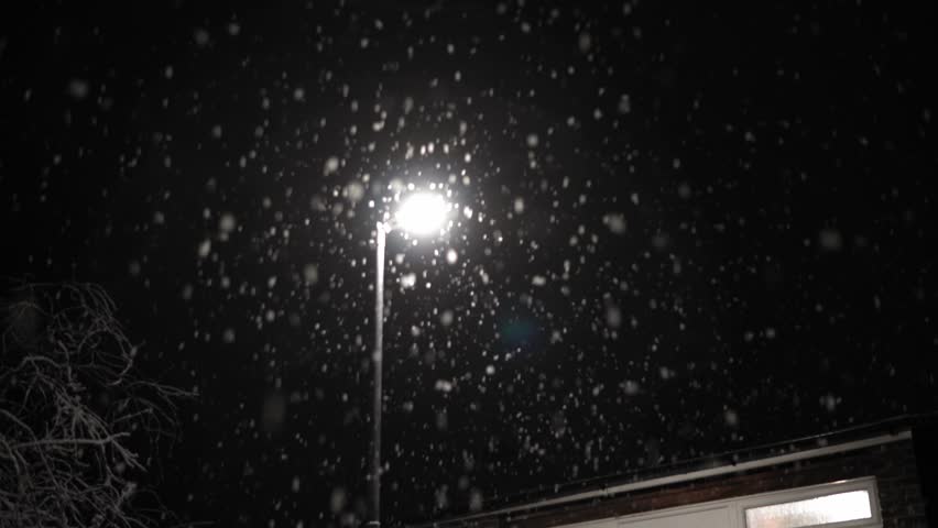 First Snowfall Overlay in United Kingdom Black Background. Falling Snowflakes in Light of Street Lamp at Night Road - Winter, Slowly falling snow effect. Weather Forecast, Anomaly, Emergency Concept