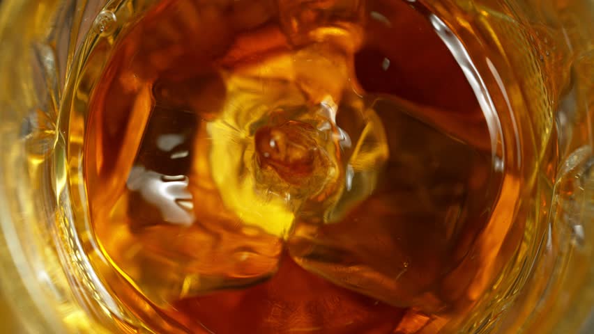 Super Slow Motion Detail Shot of Drop Falling into Glass with Whiskey and Ice Cubes at 1000fps. | Shutterstock HD Video #1101037511
