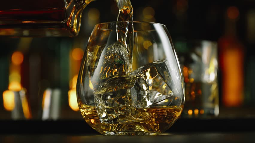 Super Slow Motion Shot of Pouring Alcohol into Glass with Ice Cubes at 1000fps with Camera Motion.