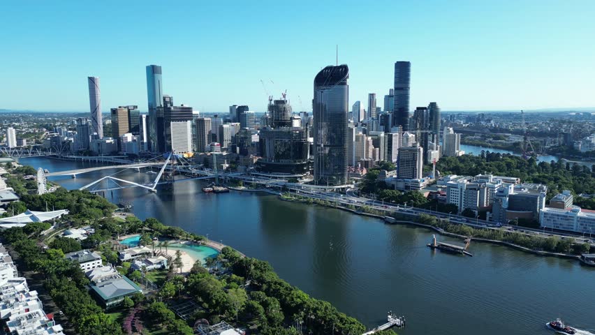 Drone shot of Brisbane City and South Bank. Taken from above South Bank Parklands. Many construction cranes at work, building bridge to the new Queens Wharf Casino development. Royalty-Free Stock Footage #1101038515