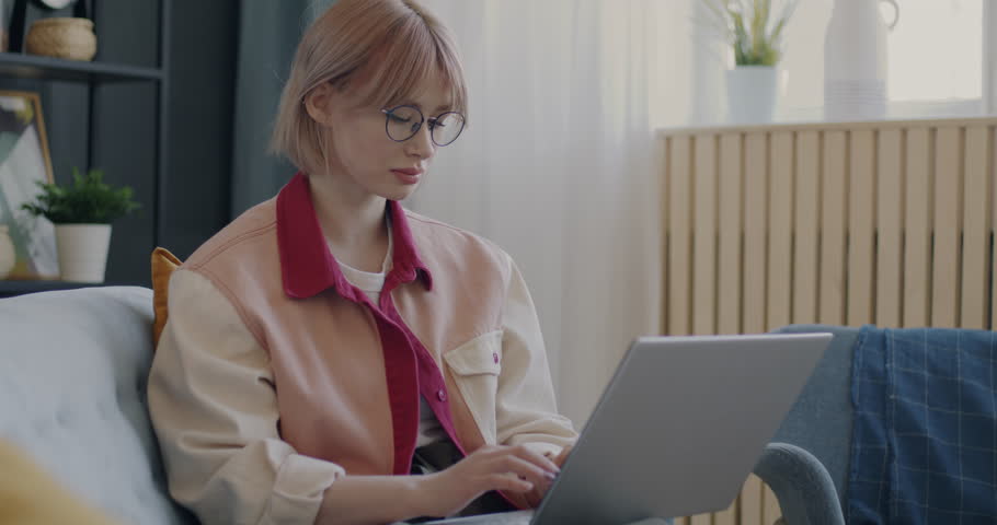 Creative young lady working from home typing using laptop concentrated on remote job. Youth and professional occupation concept. | Shutterstock HD Video #1101039211