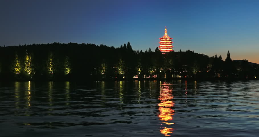 Beautiful West Lake natural scenery at night in Hangzhou, China. Ancient Leifeng Pagoda and mountain with lake scenery in Hangzhou. Famous travel destinations in China.