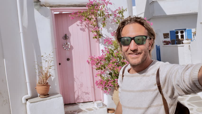 Young man takes a selfie in a cute little village in Greece