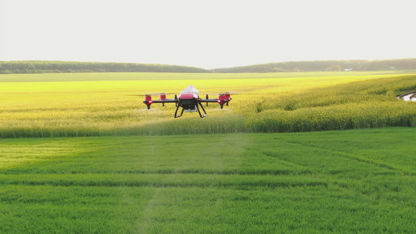 Agricultural drone for spraying fertilizers flies in the air over a green field. Innovations of smart agriculture, agro-industrial technologies. Aerial shot | Shutterstock HD Video #1101043591
