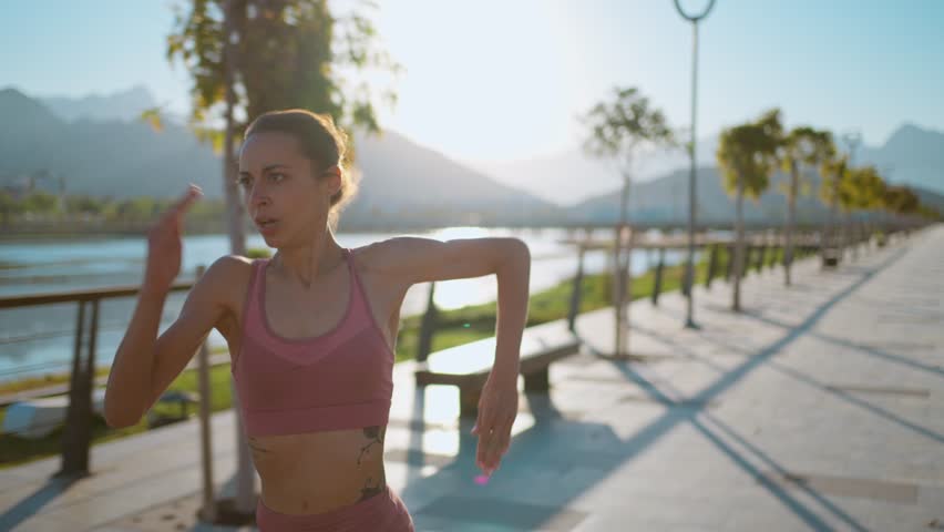 Closeup of strong athletic woman runner in fast motion run marathon training outdoors