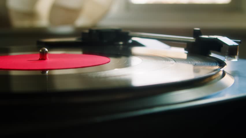 Record Player Vinyl Playing Gramophone. The hand puts the head of a vinyl player on a vinyl record close-up. Playing retro music on a black record  Royalty-Free Stock Footage #1101045031